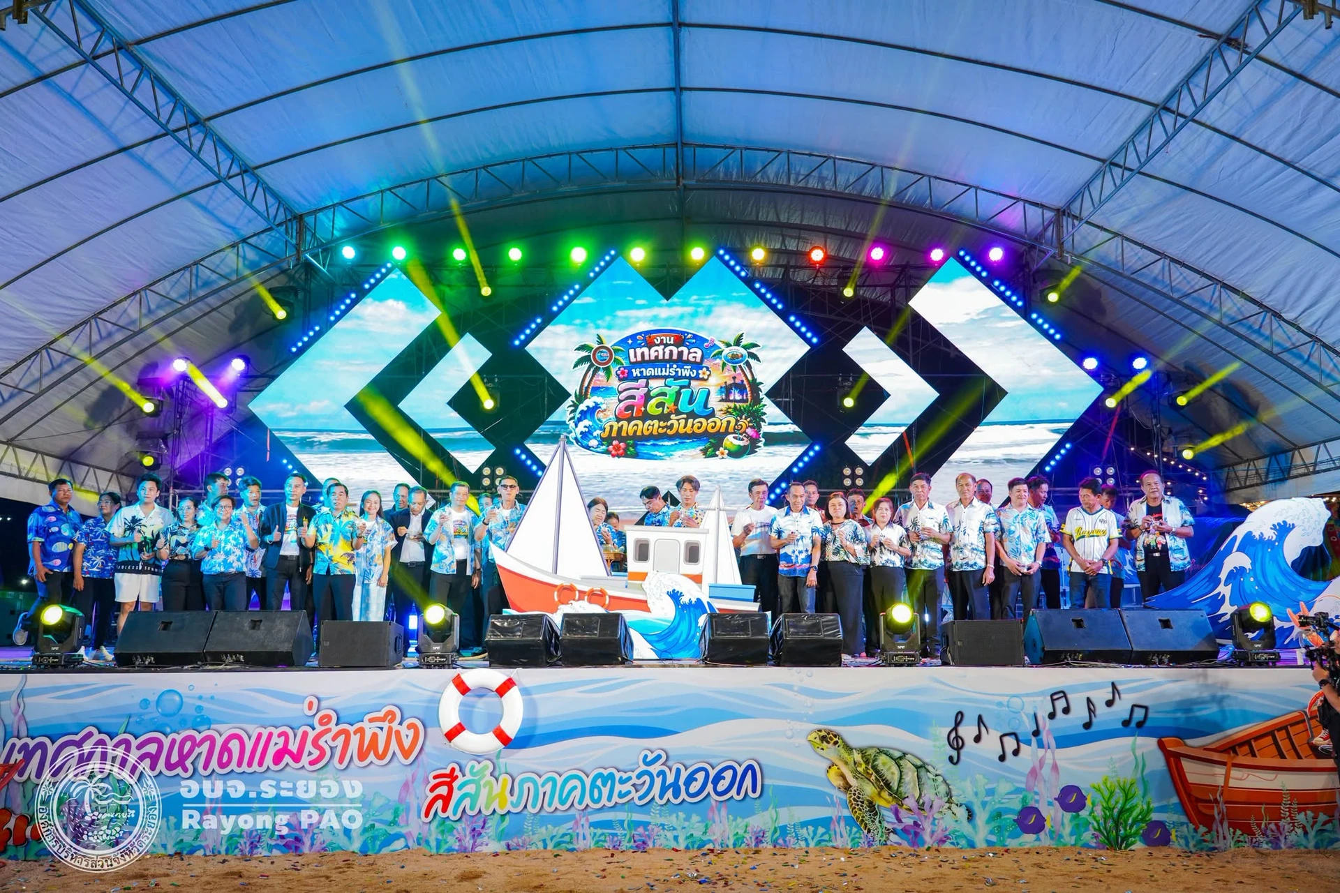 เวทีมุมกว้างพร้อมเรือจำลองจากรายงานพิธีเปิดเทศกาลหาดแม่รำพึงปี 2569
