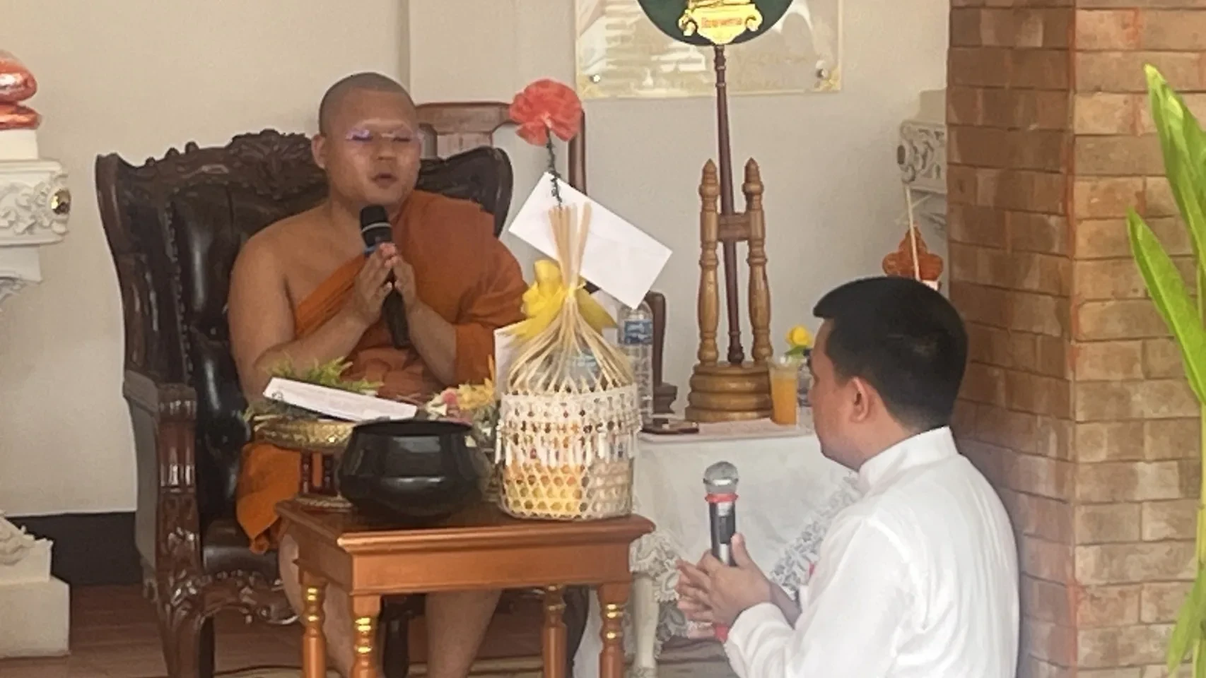 โต๊ะพร้อมก๋วยสลากและไมโครโฟนภายในวัดยางกวง จากรายงานกิจกรรมปี 2568
