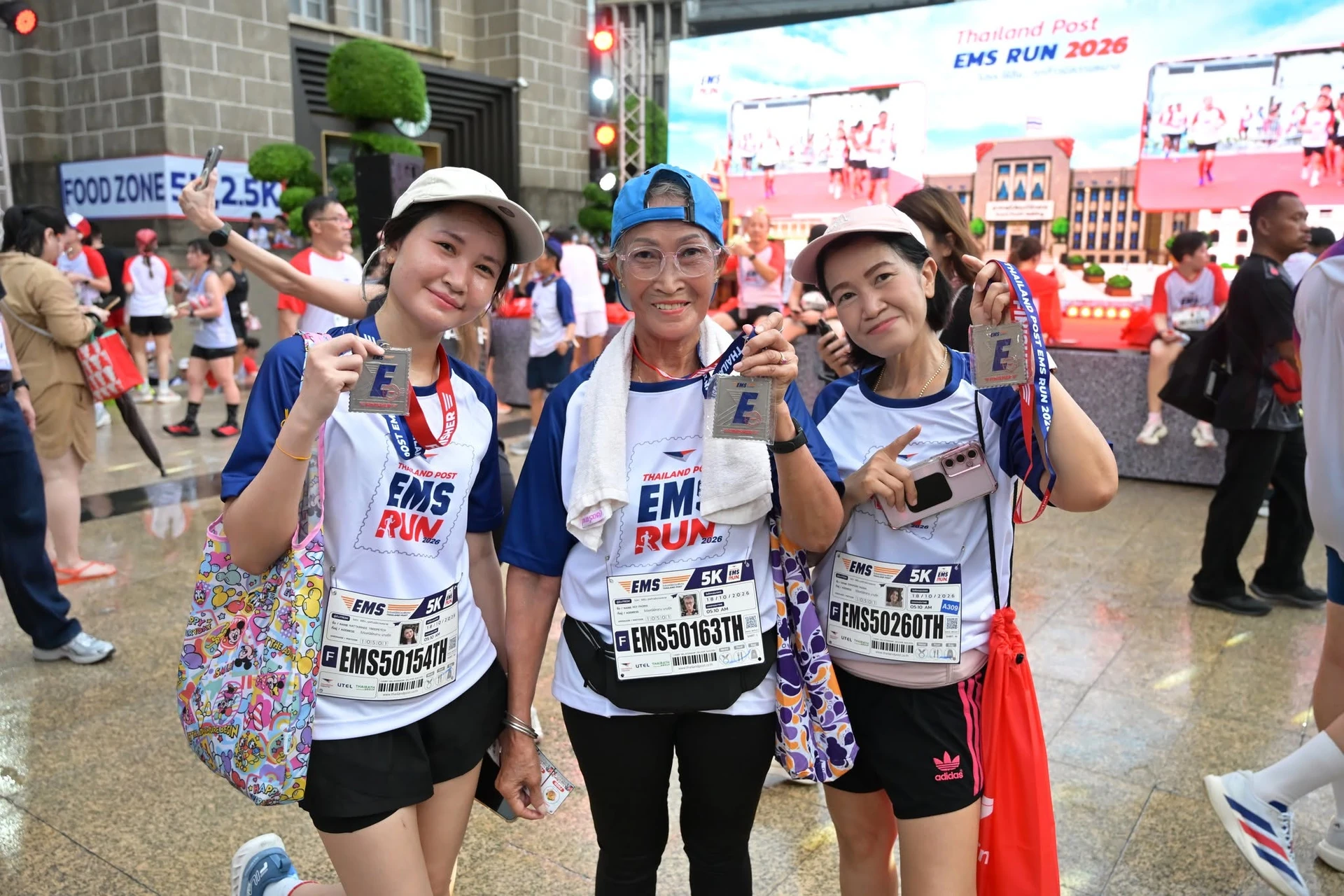 กลุ่มคนถือเหรียญหน้าเวที Thailand Post EMS RUN ปี 2569