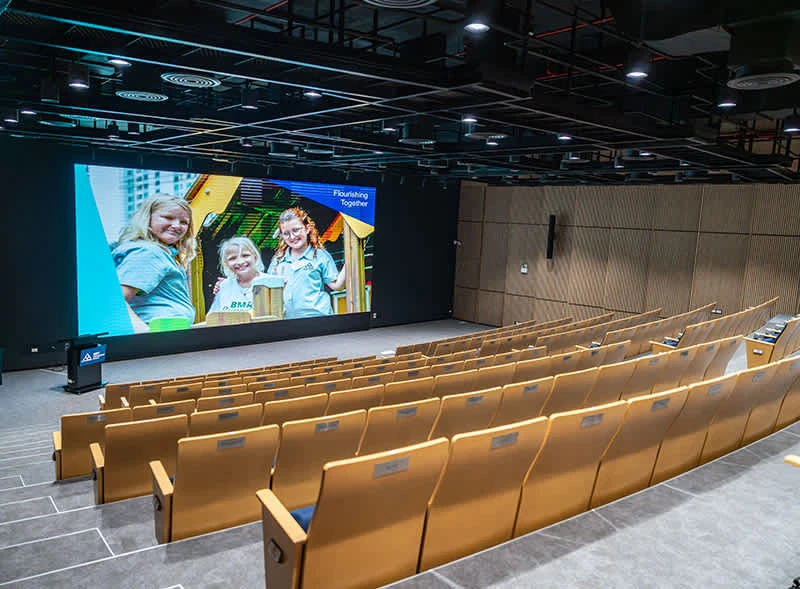 Lecture Hall ของ NIST International School จากหน้า Our Campus ทางการ — ไม่ระบุวันหรือปีถ่าย เป็นภาพห้องบรรยายว่างพร้อมภาพบนจอของโรงเรียน ใช้ประกอบสถานที่ ไม่ยืนยันว่าเป็นห้องที่ AIFE 2026 ใช้งานหรือรูปแบบจัดห้องครั้งนี้ ไม่ใช่ภาพกิจกรรมวันที่ 31 ตุลาคม–1 พฤศจิกายน 2569 การเตรียมงาน หรือสภาพปัจจุบัน