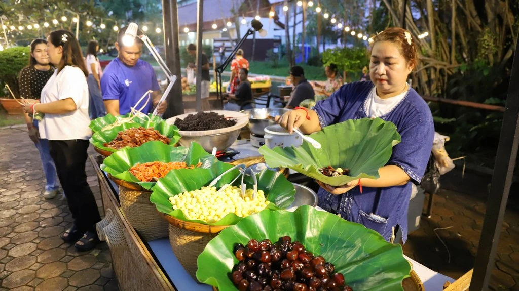 ผู้ขายจัดอาหารบนใบตองในร้านอาหารพื้นถิ่น วันเปิดงานเนรมิตอัมพวา ปี 2569