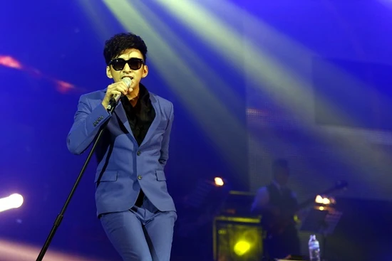 บี พีระพัฒน์ ร้องเพลงในชุดสูทสีน้ำเงินบนเวที Natural Born Singer ปี 2556
