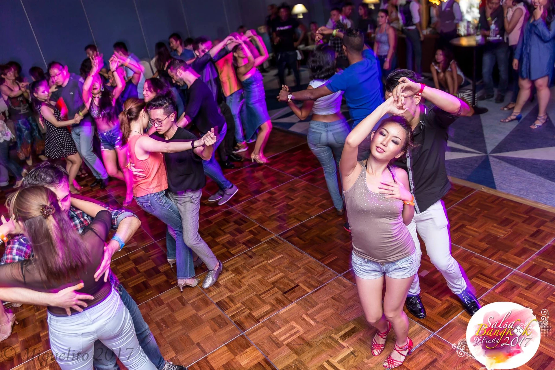 ผู้ร่วมงานหลายคู่เต้นรำบนฟลอร์ใน Salsa Bangkok Fiesta ปี 2560 พร้อมลายน้ำต้นฉบับ