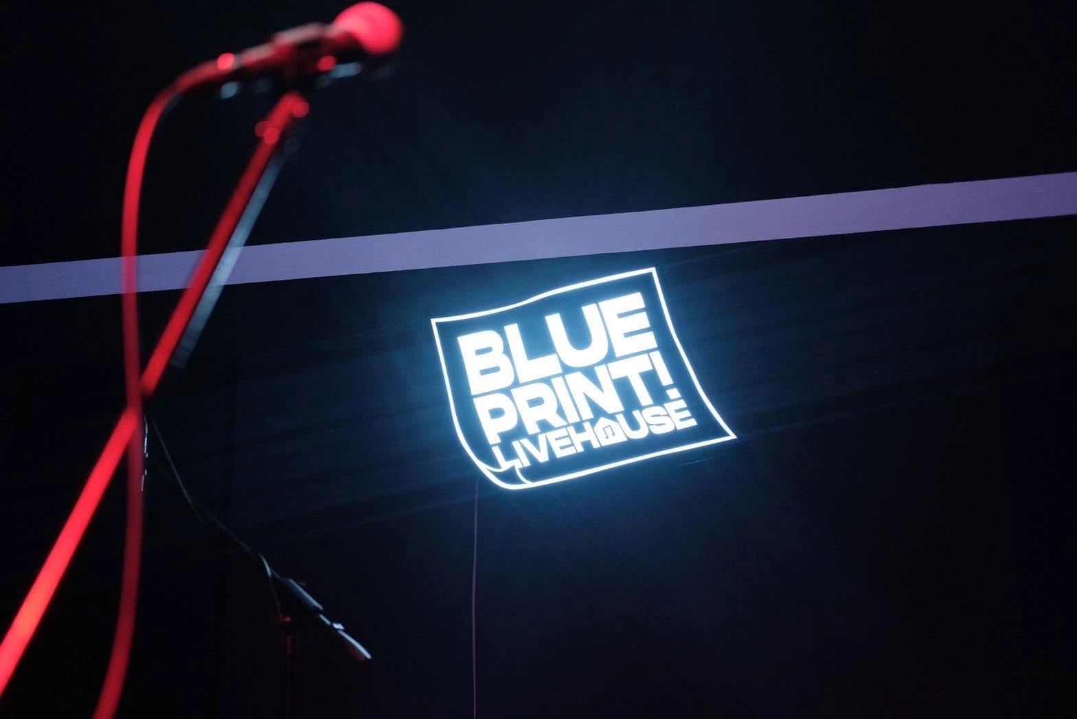 ป้าย Blueprint Livehouse และไมโครโฟนบริเวณเวที ในภาพหน้าปกที่เพจเจ้าของสถานที่เผยแพร่ 18 พฤษภาคม 2566 — ไม่ระบุปีถ่าย ไม่ใช่งาน A Night of Rock Vibes และไม่ยืนยันสภาพสถานที่ปัจจุบัน