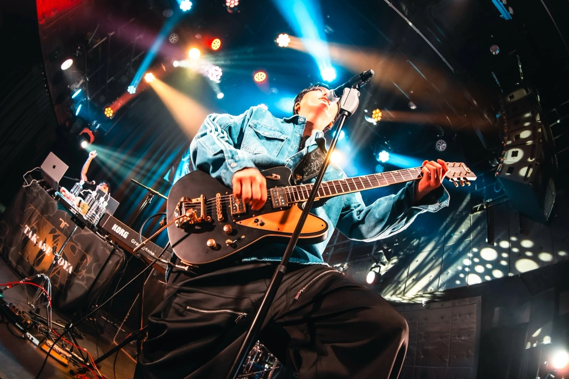 TAKASE TOYA เล่นกีตาร์และร้องเพลงในภาพจากรายงานจบ ASIA TOUR 2026 รอบโตเกียว