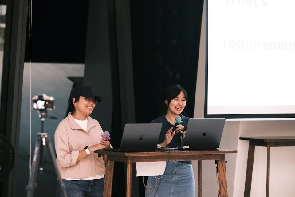 ผู้บรรยายสองคนพูดหน้าคอมพิวเตอร์และจอใน QA & Testers Thailand Meetup รอบเมษายน 2569