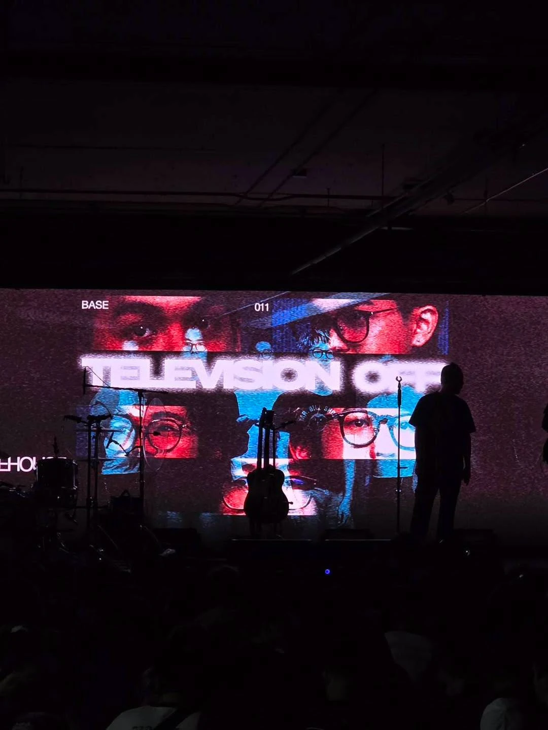 ป้าย BASE 011 พร้อมอุปกรณ์บนเวทีและเงาคนในพื้นที่งาน Volume Livehouse ชั้น B ภาพรอบก่อน ไม่ระบุวันและปีถ่าย