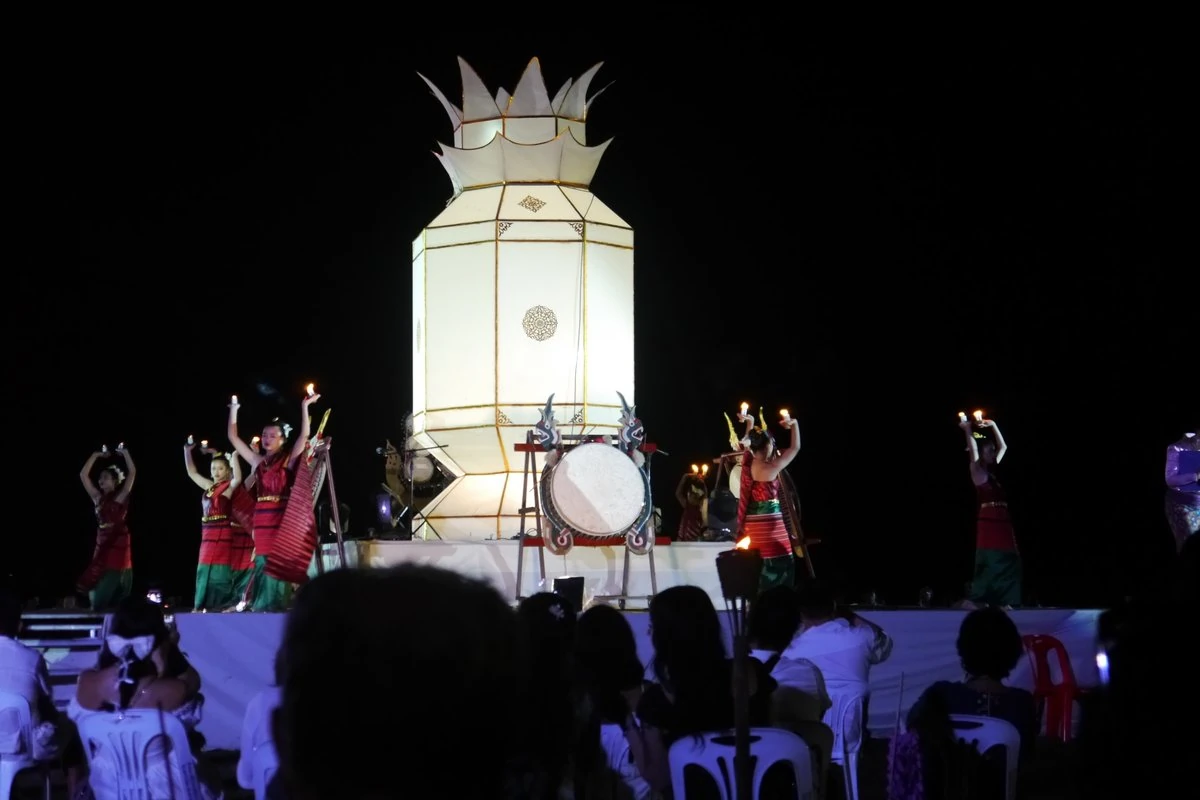 นักแสดงถือเทียนแสดงบนเวทีหน้าโคมขนาดใหญ่ใน Moonlight Sky Lantern Festival ปี 2568