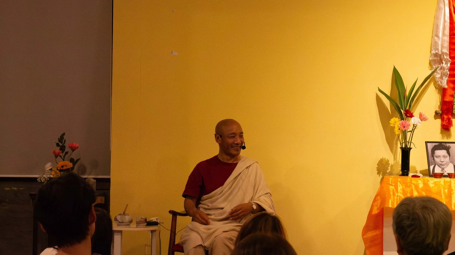ผู้บรรยายนั่งพร้อมไมโครโฟนจากปาฐกถา What is Vajrayana ที่วัชรสิทธา ปี 2567 ไม่ใช่ Three Turnings ปี 2569