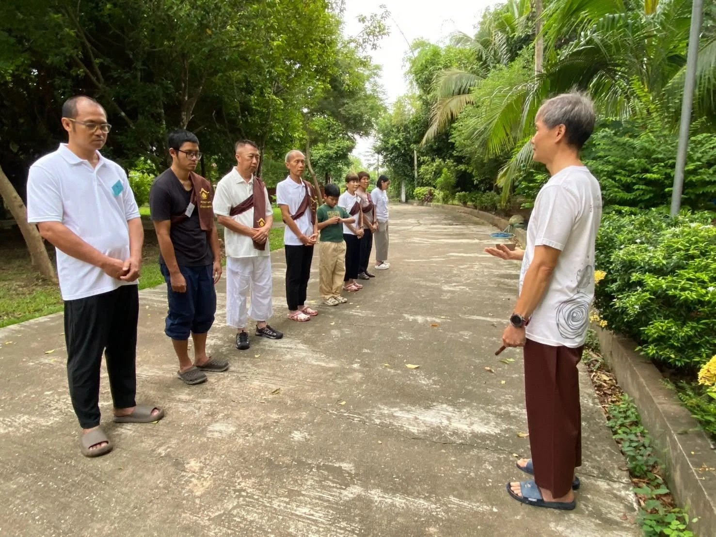 ผู้ร่วมกิจกรรมยืนกลางแจ้ง จากรายงานคอร์สฟื้นกาย เยียวยาใจ บ้านธรรมทาน รอบเดียวกันปี 2569