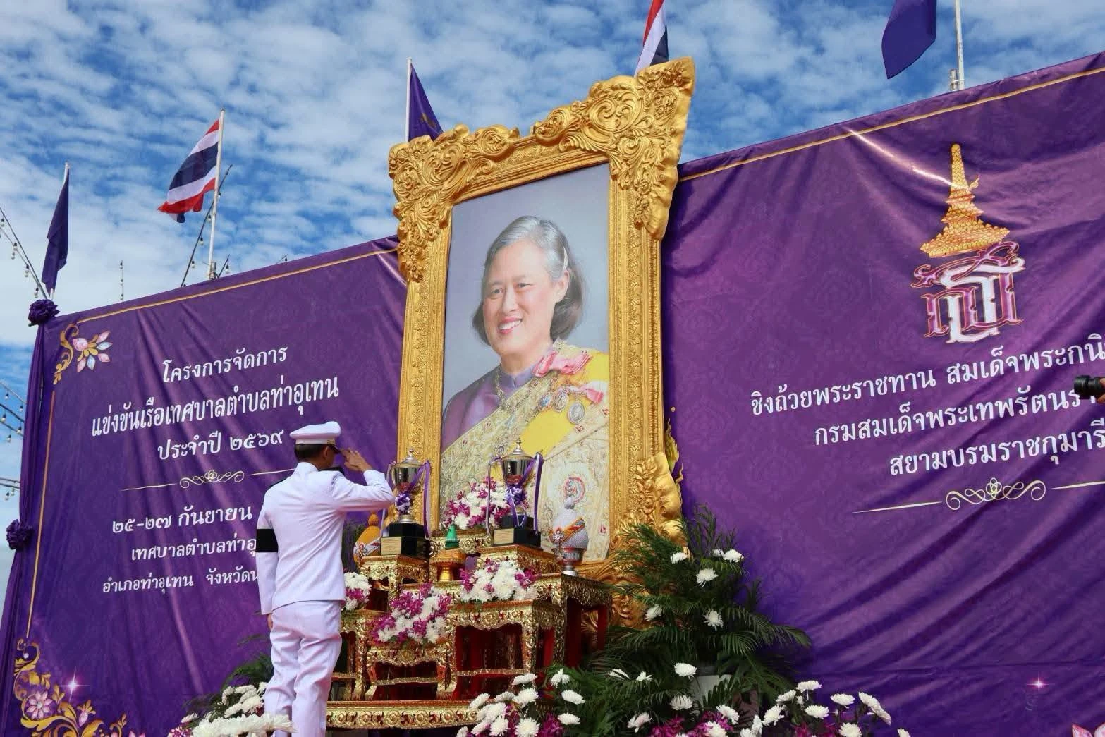 ผู้ร่วมพิธีหน้าโต๊ะพิธีและฉากป้ายแข่งเรือเทศบาลตำบลท่าอุเทน ประจำปี 2569